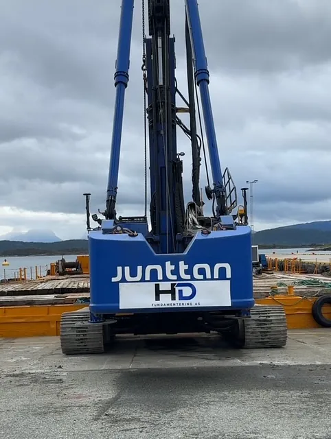 Blå borerigg fra Junttan HD Fundamentering står på kaiområde med fjord og fjell rundt.